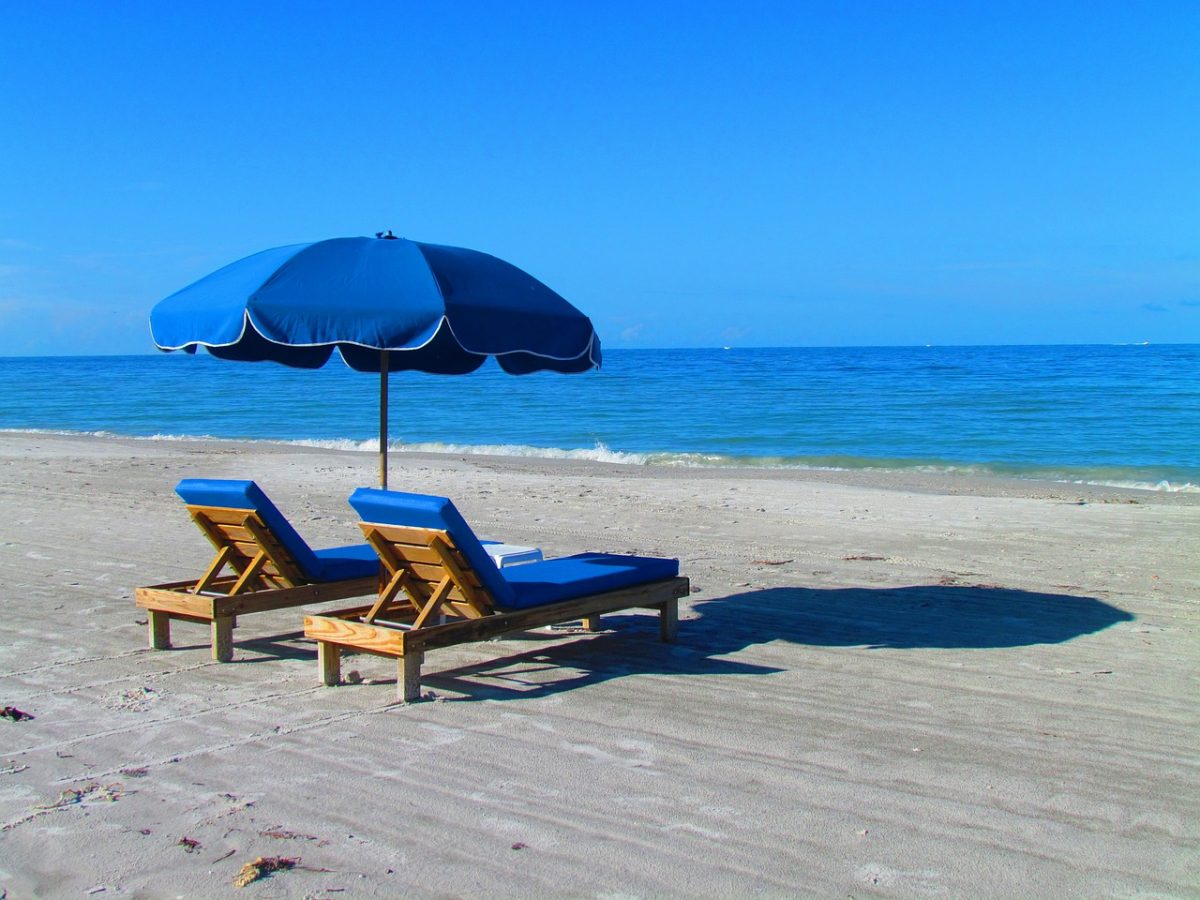 two beach chairs sitting on beach