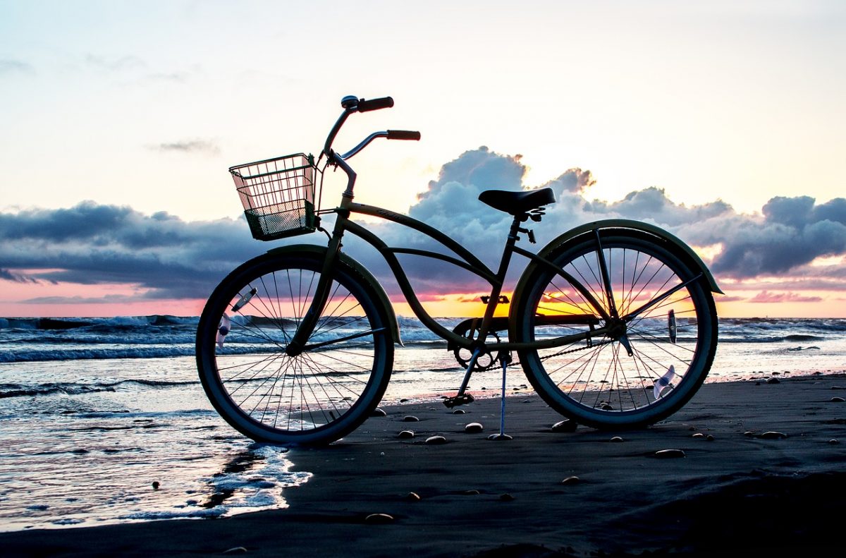 bicycle on beach with sunset in background