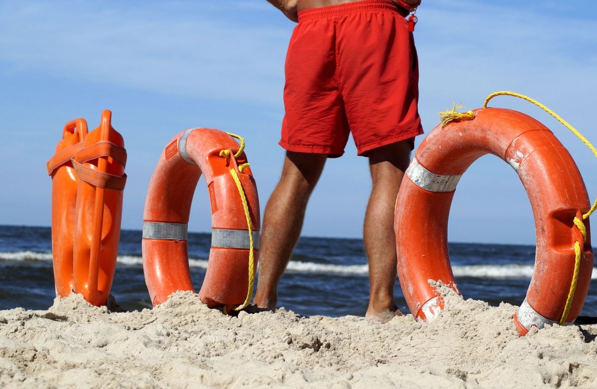 close=up shot of  a lifeguard surrounded by lifeguard equipment 
