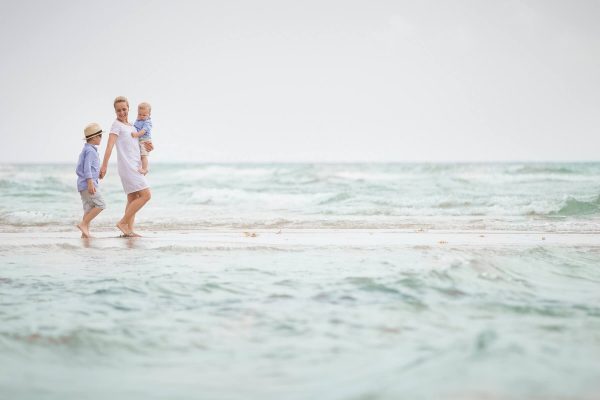 mother and children on the beach after making their family vacation decision between Kure Beach vs. Wrightsville Beach