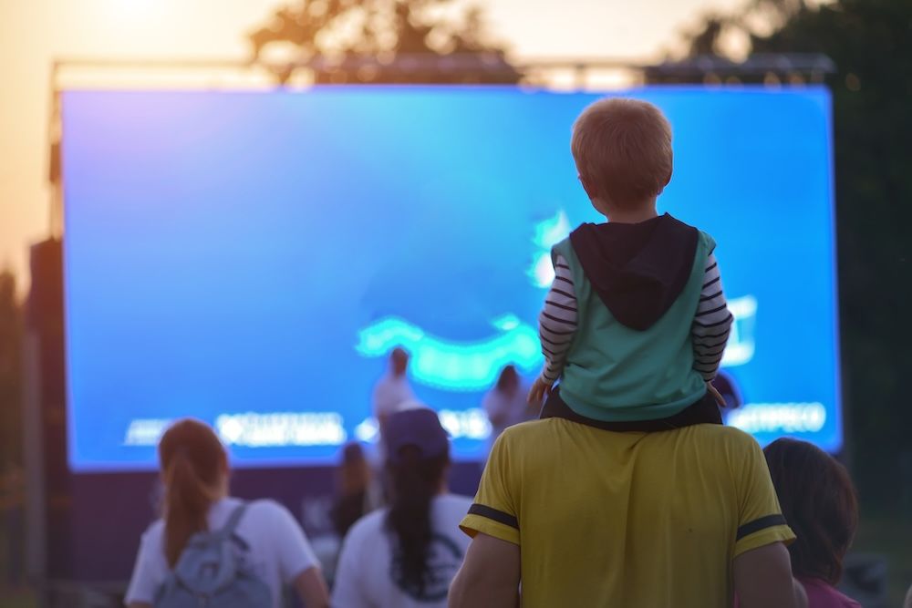 Father and child watching movie outside